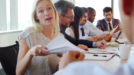 Group-Of-Businesspeople-Meeting-Around-Table-In-Boardroom