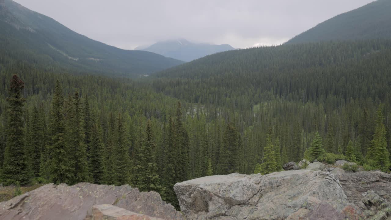 View of the mountain range surrounding Moraine Lake in Banff National Park Alberta on a slightly foggy afternoon.