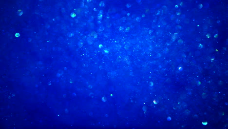 Abstract-blue-sparkly-particle-background-with-bokeh-light-and-shiny-frozen-crystals-in-water-LOOP