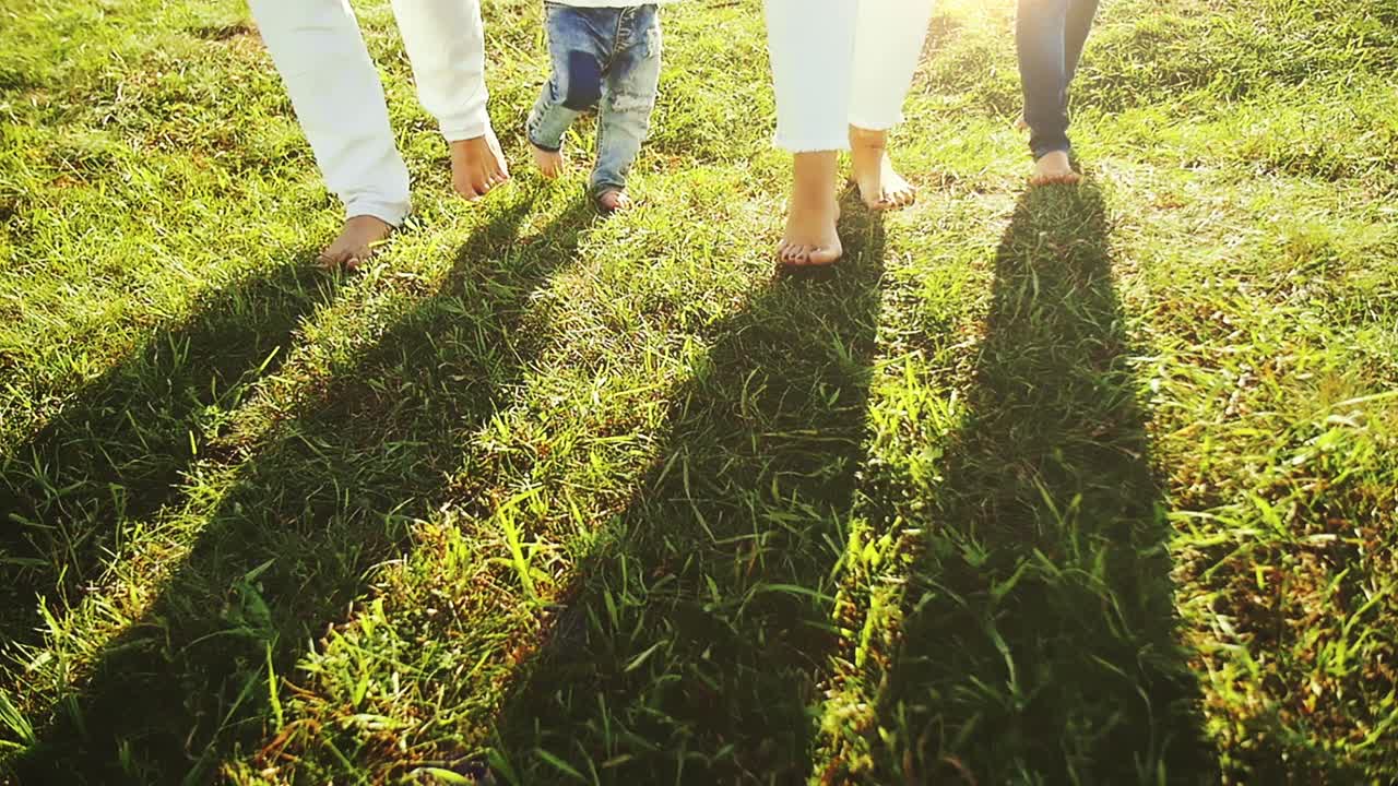 Family Walking Barefoot in Grass