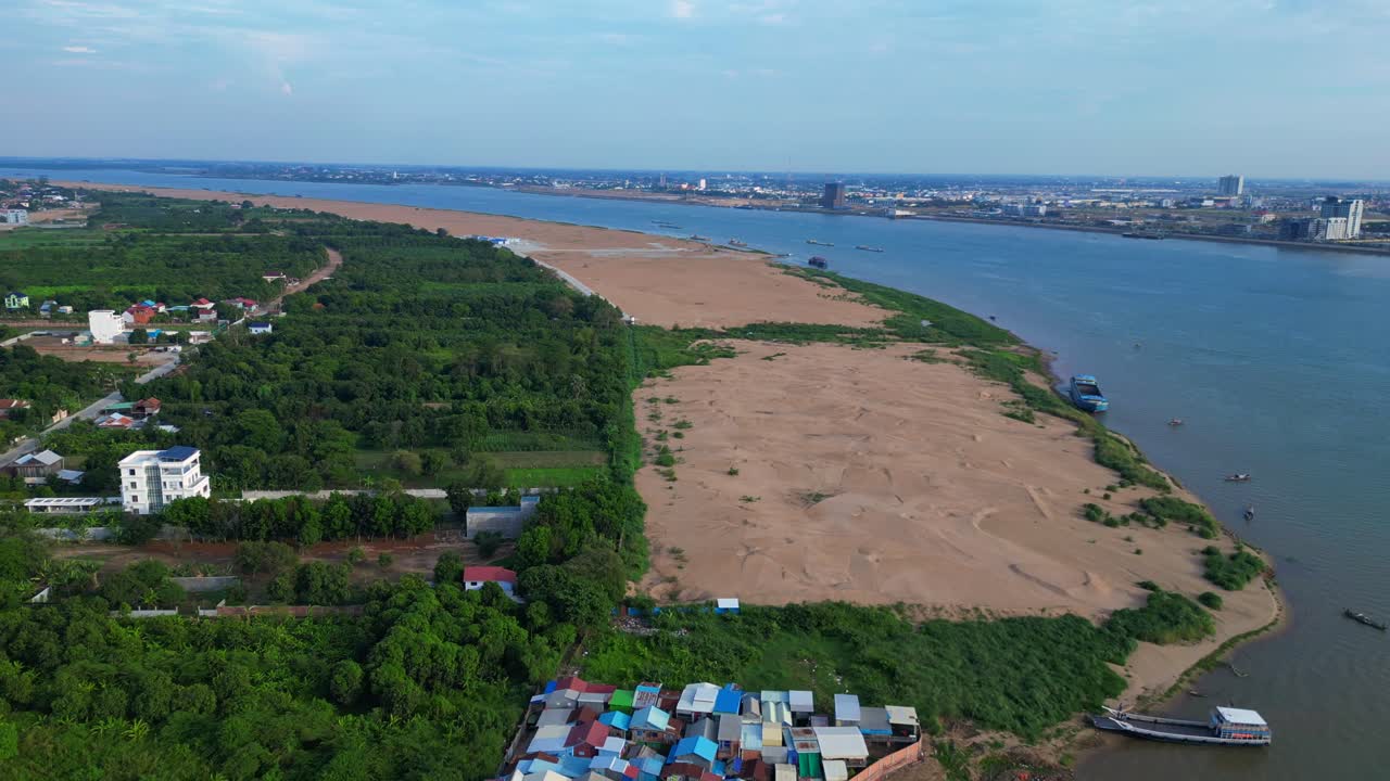 fishing village with colorful shacks along the Mekong river in Cambodia, a developing country in Southeast Asia. Smooth aerial view flight fly reverse drone