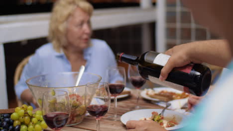 Man-pouring-red-wine-during-the-dinner