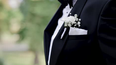 the groom touching the boutonniere flower
