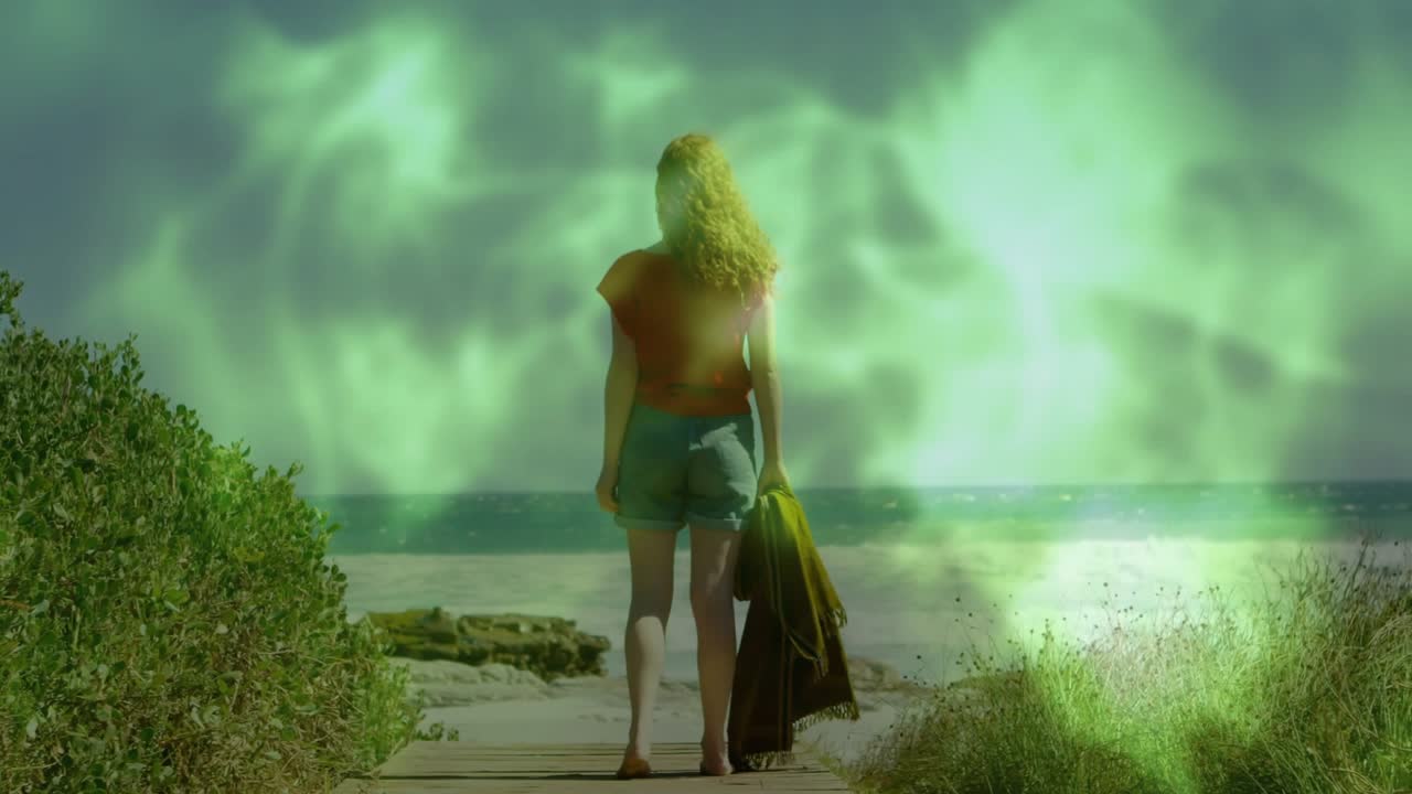 Adult woman walking boardwalk facing ocean in environment as green mist rising swirling around legs