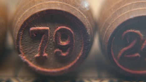 cinematic macro smooth shot of bingo wooden barrels in a row, woody figures, old numbers vintage board game, number 79, slow motion, commercial gimbal movement, dreamy lighting, pan right