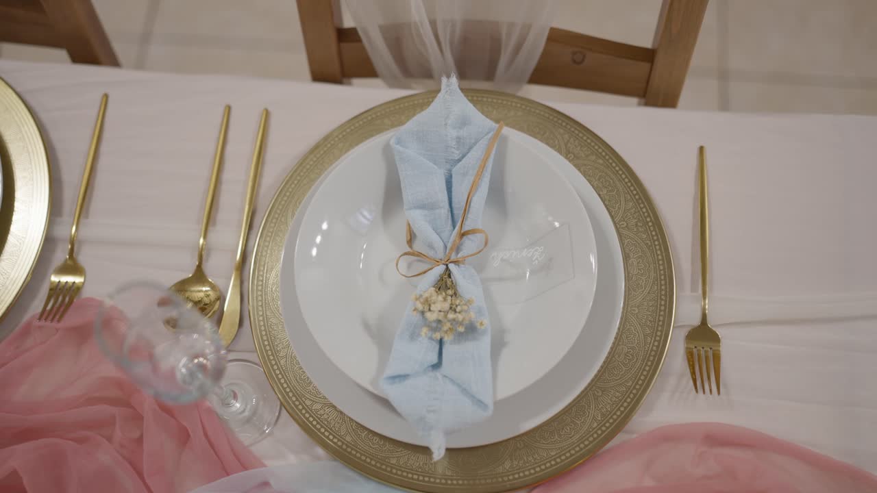 Close-up shot of a wedding reception plate. Beautiful and luxurious decorations in golden colors await the guests