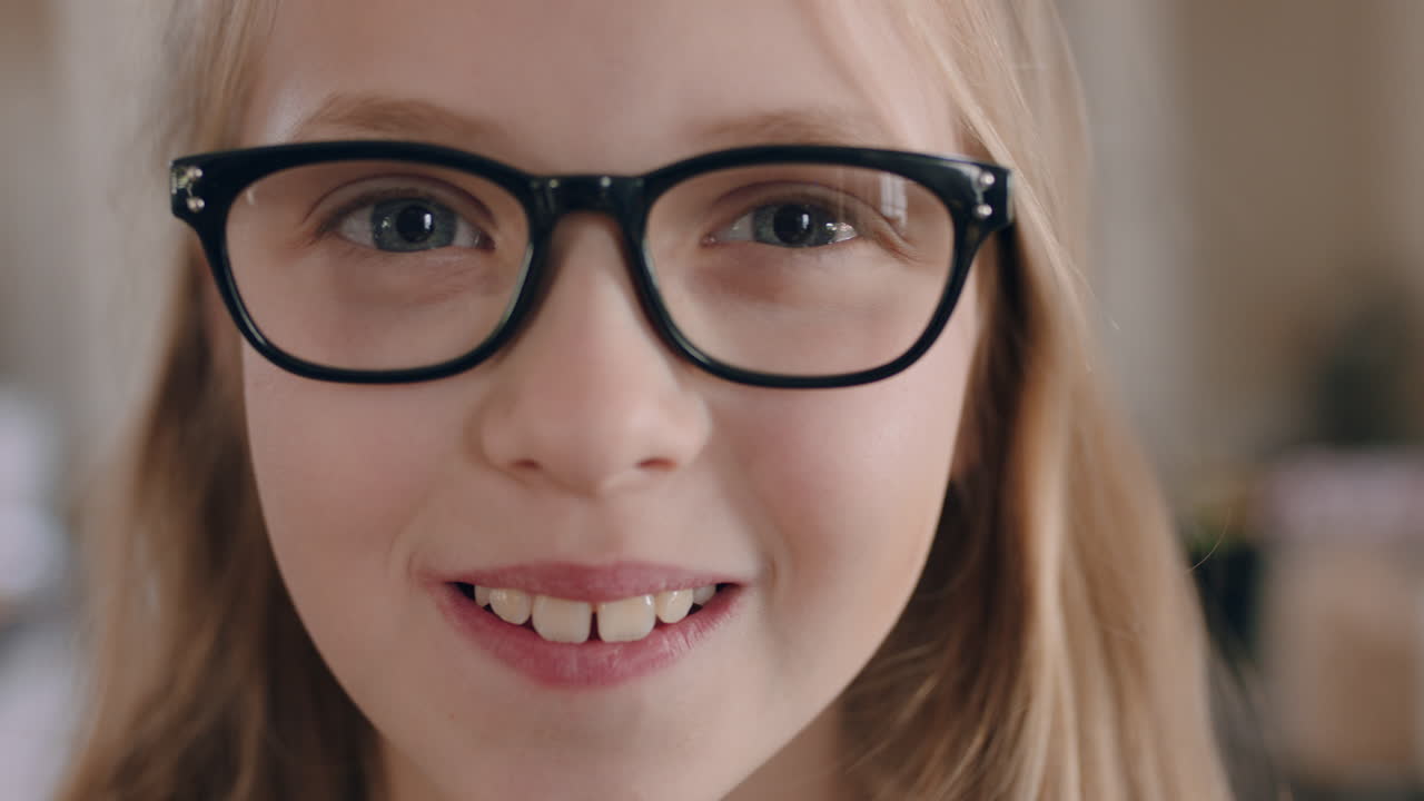 portret pięknej szczęśliwej dziewczyny uśmiechającej się w okularach patrzącej na kamerę przyjazne dziecko cieszące się szczęściem dzieciństwa