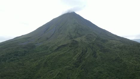 Vista-Aérea-En-Movimiento,-Vista-Panorámica-Del-Volcán-Arena-En-Costa-Rica,-Nubes-En-La-Punta-Del-Volcán-En-El-Fondo