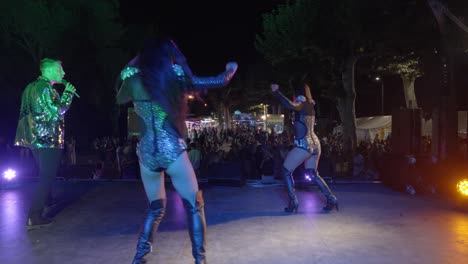 slow motion shot of backup dancers spinning whilst a singer sigs on stage