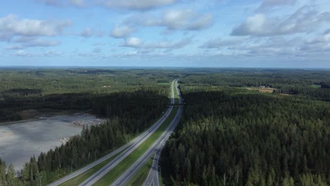 Vista-Aérea:-La-Carretera-Dividida-Atraviesa-Un-Bosque-De-Coníferas-Ondulado