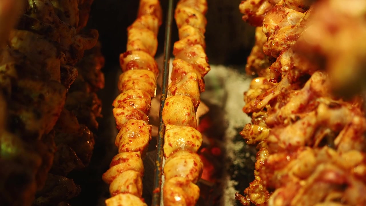 Spiedini di pollo marinati che ruotano su un girarrosto