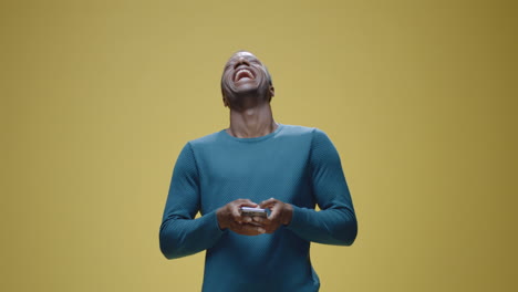 man laughing and smiling while using a smartphone