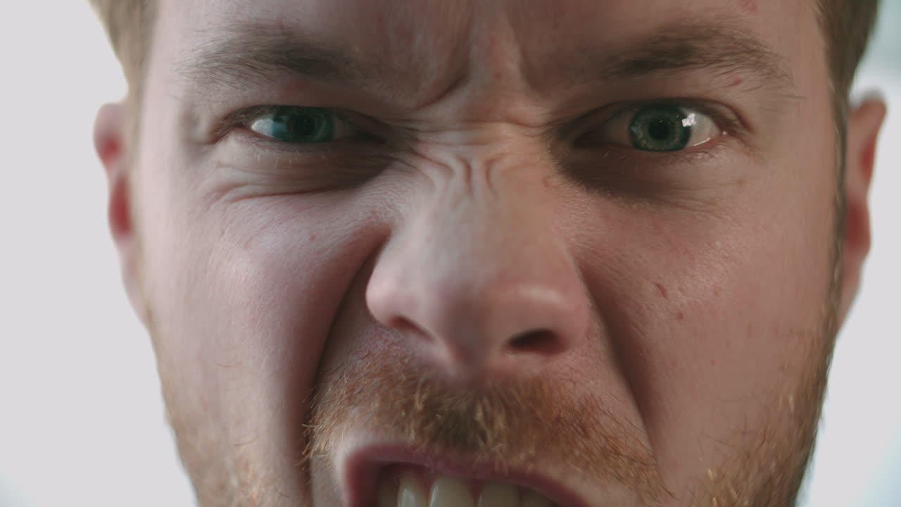 un hombre hace una cara graciosa luego sonríe, de cerca, detalle