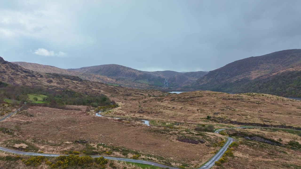 Paisajes de Irlanda: revelación con dron del lago y cascadas del valle de Gleninchquin con carretera sinuosa, Kerry, Irlanda, ubicaciones épicas