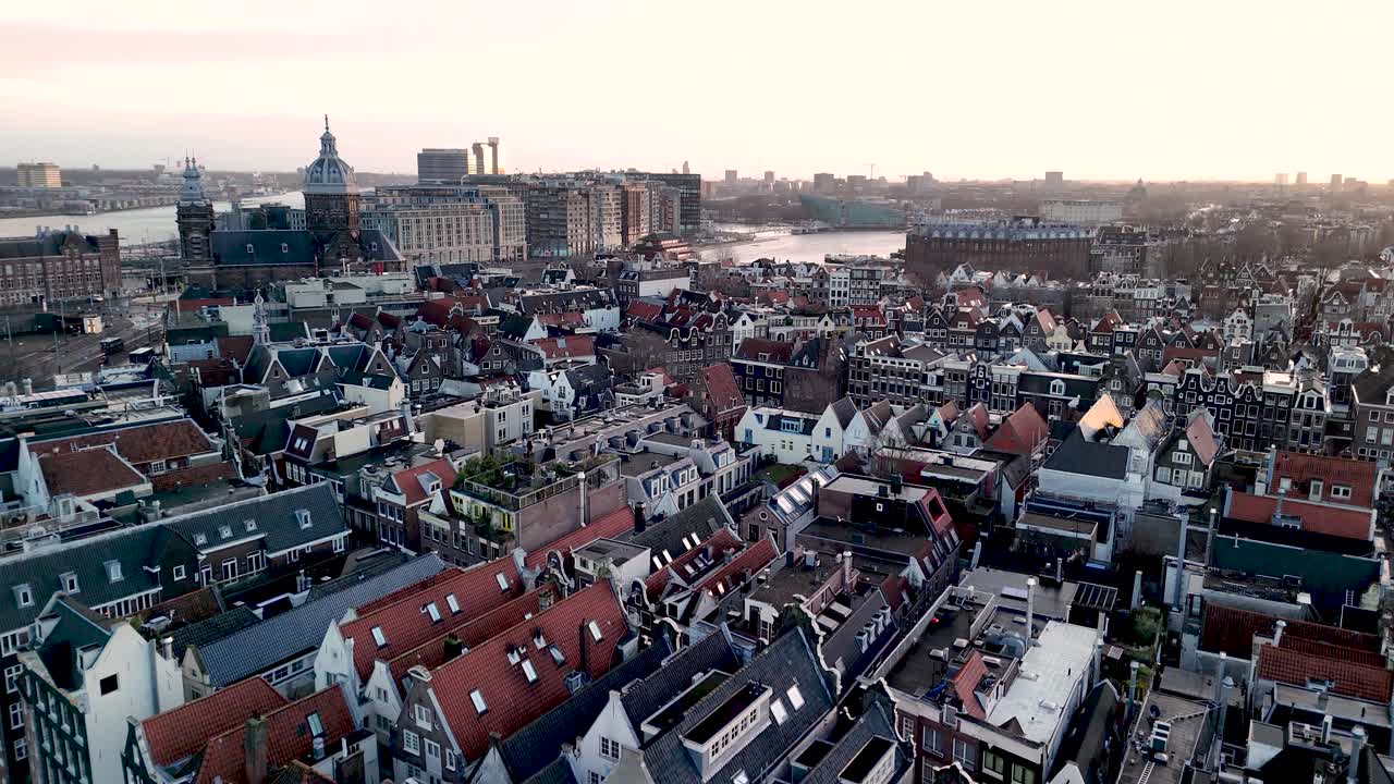 This stunning aerial view captures Amsterdam's famous canals and unique architecture at sunset. The warm colors create a beautiful contrast with the city skyline