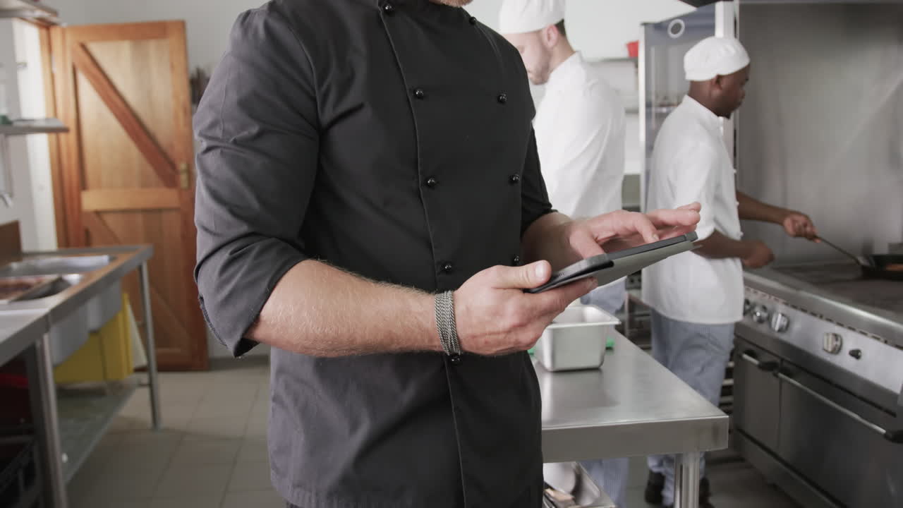 cocinero caucásico usando una tableta en la cocina, cámara lenta