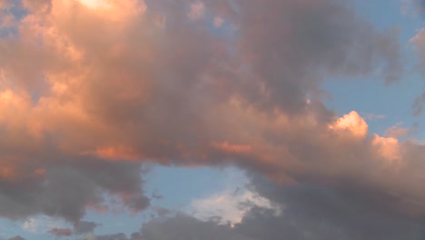 orange reflects off time lapse clouds at sunset