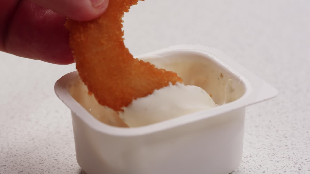 sumergir el anillo de cebolla en la salsa