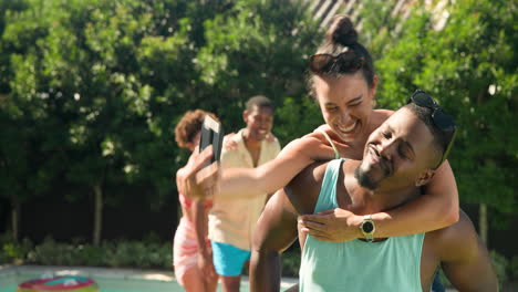 diverse friends enjoying piggyback rides and laughter by pool on sunny day