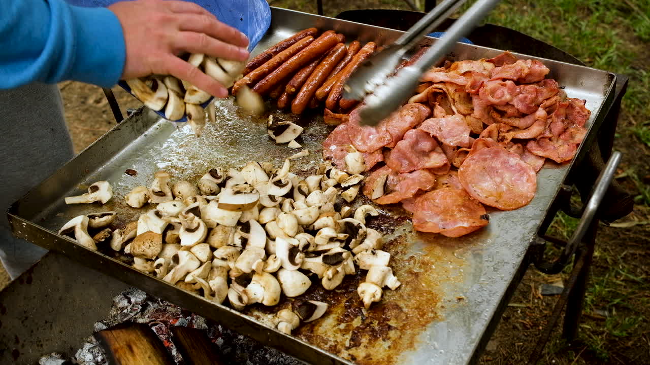 큰 캠프 프라이팬에 버섯 추가 - 모닥불에 아침 요리하기