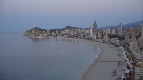 crepúsculo en la playa de benidorm, centros turísticos y costa desde arriba, 4k