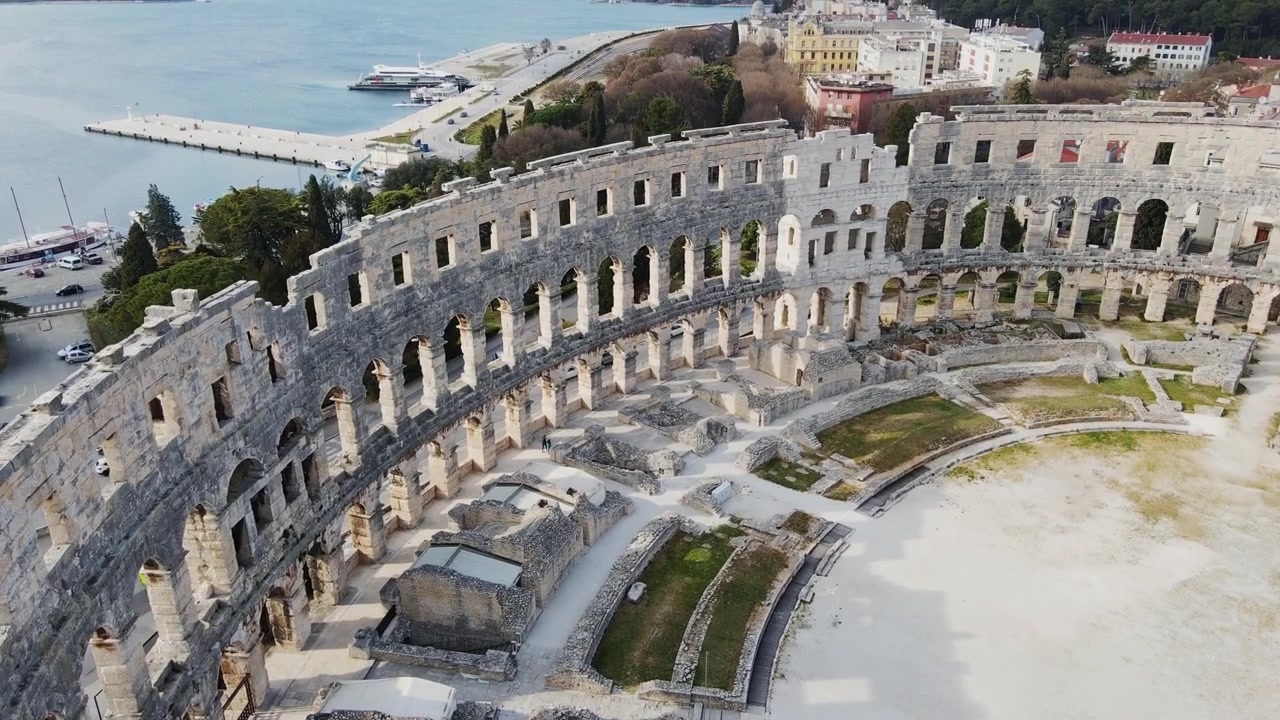 Drone vola sopra il Colosseo, scendendo lentamente mentre mostra uccelli in volo - 4K