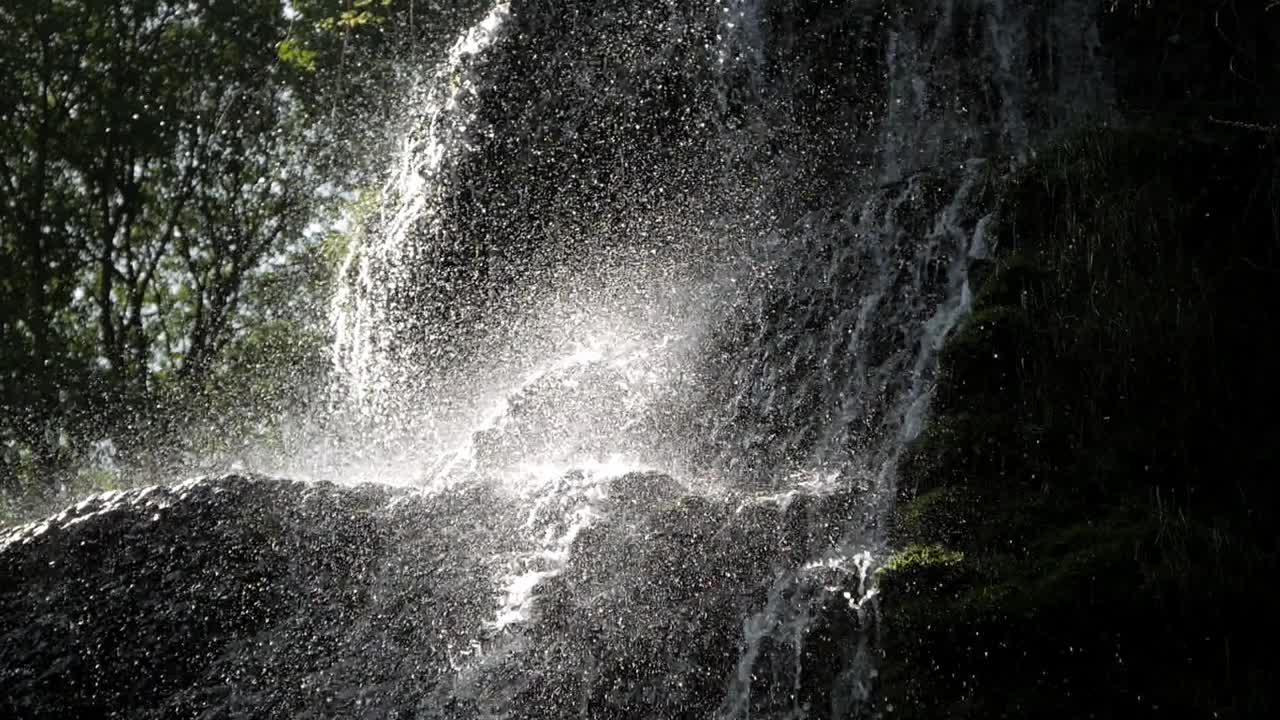 Closeup beautiful waterfall cascade. Water flow drop on rock. Sunlight rays shine on splashes. Amazing scenery. Monasterio de Piedra park, Zaragoza, Aragon, Spain