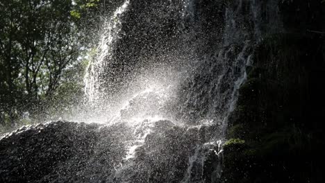 closeup beautiful waterfall cascade. water flow drop on rock. sunlight rays shine on splashes. amazing scenery. monasterio de piedra park, zaragoza, aragon, spain