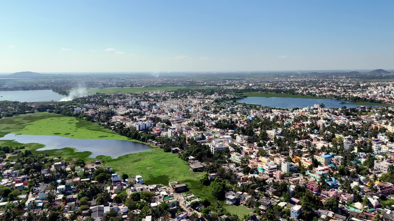 Aerial video of Perungalathur lake and surroundings provides a sweeping panoramic view of a vast urban landscape. The city extends far into the horizon