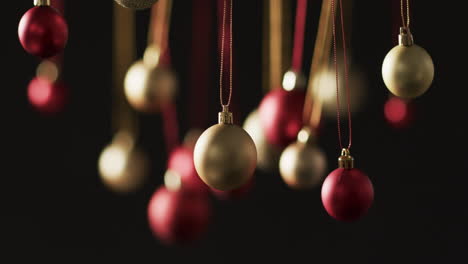 Video-of-gold-and-red-baubles-christmas-decorations-with-copy-space-on-black-background