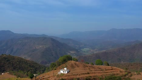 aerial view overlooking farmlands and a valley town, in the mountains of north india