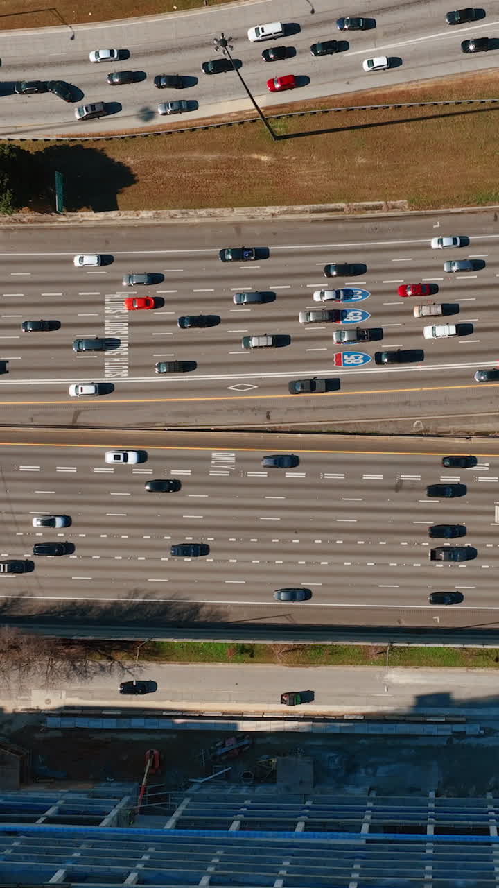 Drone zooming out interstate 85 road intersection in Atlanta, USA with traffic on multiple flyovers. Vertical video