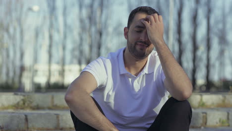 thoughtful young man sitting outdoor.