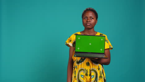 Optimistic-gorgeous-girl-holding-a-pc-with-isolated-green-screen