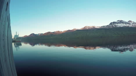 vakker refleksjon av soloppgang i bukten i faskrudsfjordur på øst-iceland