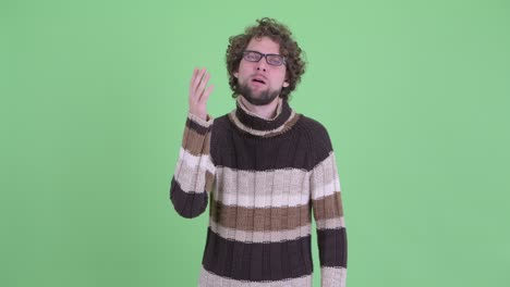 un joven guapo con barba y cabello rizado.