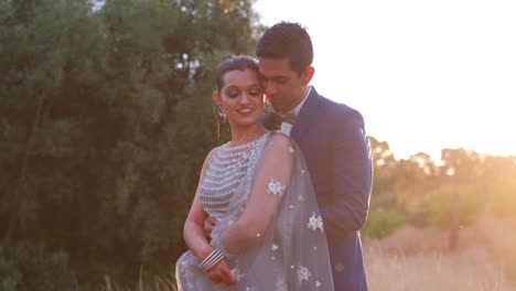 indian bride and groom posing for photo shoot outdoors in nature - medium shot