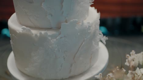 detailed close-up of a white tiered wedding cake with a textured surface, elegantly displayed