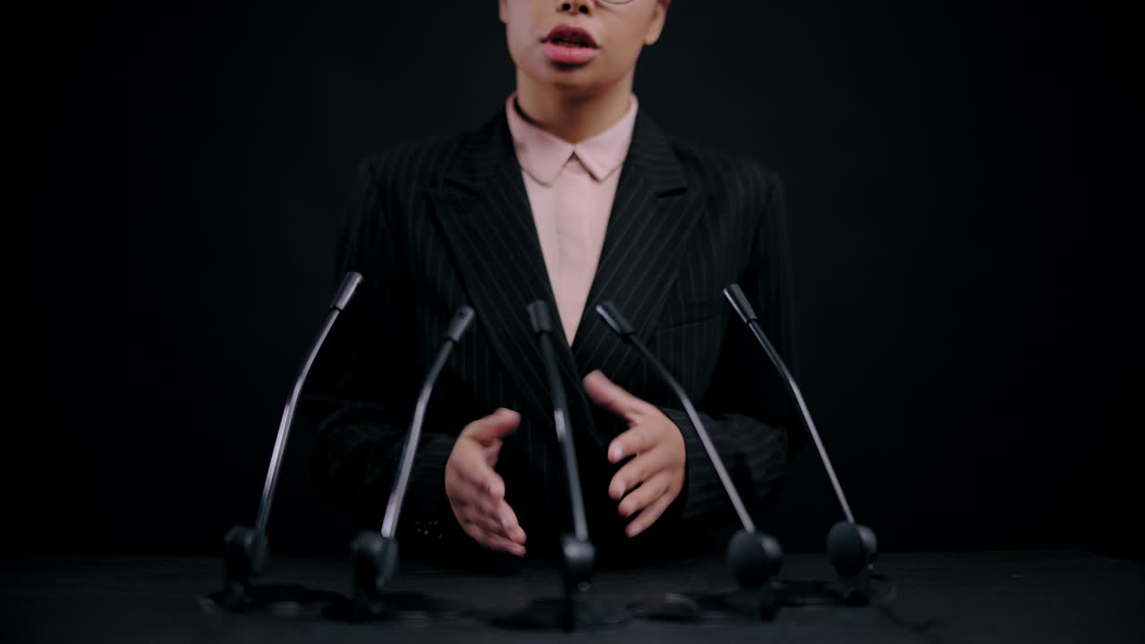 성공한 사업가 여성이 슈트를 입고 연설을 하고, 코치가 경험을 공유합니다.