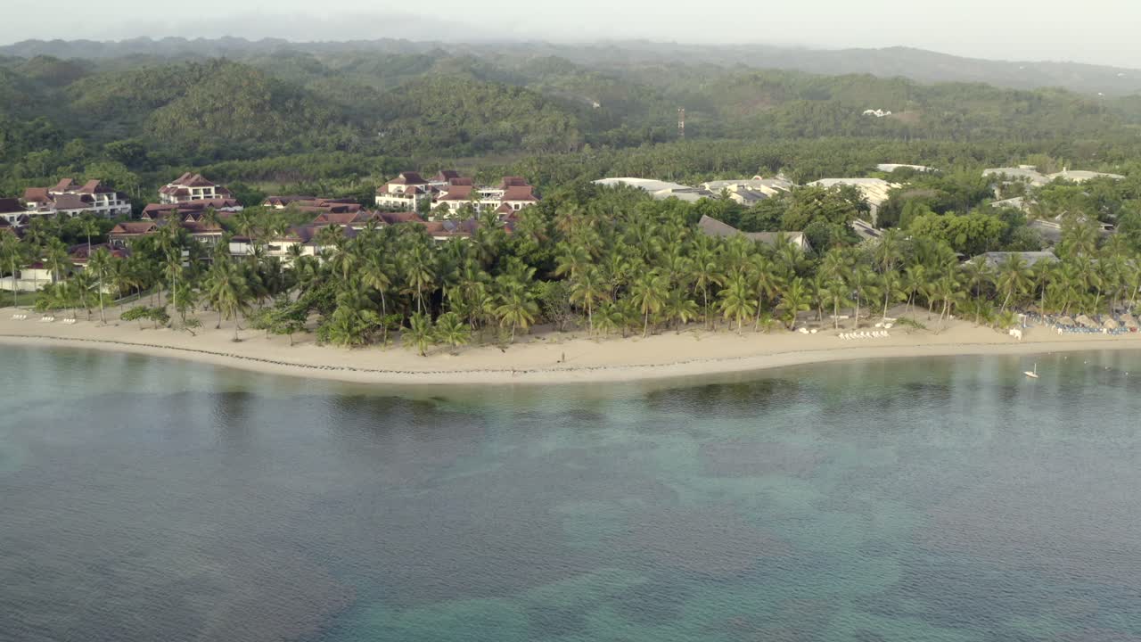 vista de drones del océano, sombrillas y playa de arena caribeña, playa grand bahia principe en la península de samana, república dominicana