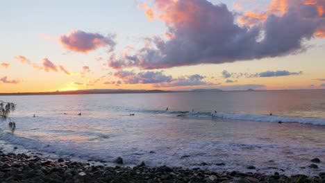 puesta de sol dorada y costa ondulada que disfrutan los surfistas en el parque nacional noosa en queensland
