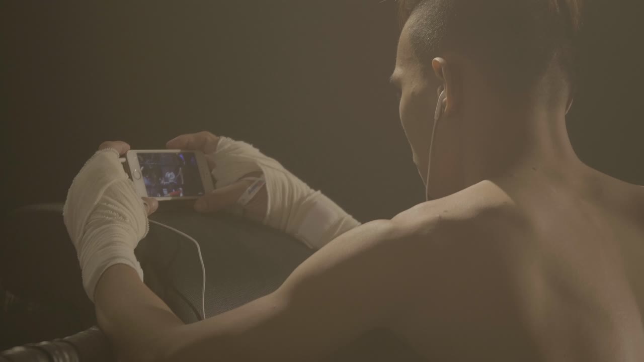 boxeador relajándose y viendo video en su teléfono inteligente