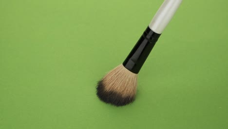 vertical movement of the brush for makeup on a green background.