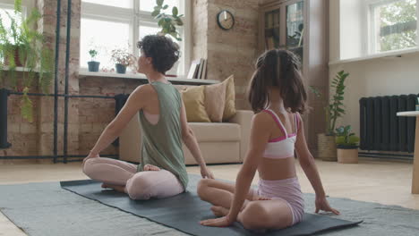 madre e hija haciendo yoga en casa