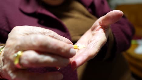 Manos-De-Ancianos-Sosteniendo-Pastillas-Y-Revisando,-Contemplando-La-Medicación