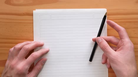 mano golpeando la pluma sobre el papel mientras piensa en una idea