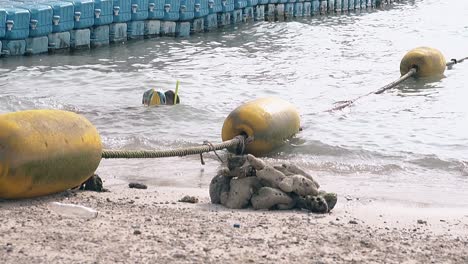 boy with inflatable armlets and mask in ocean slow motion