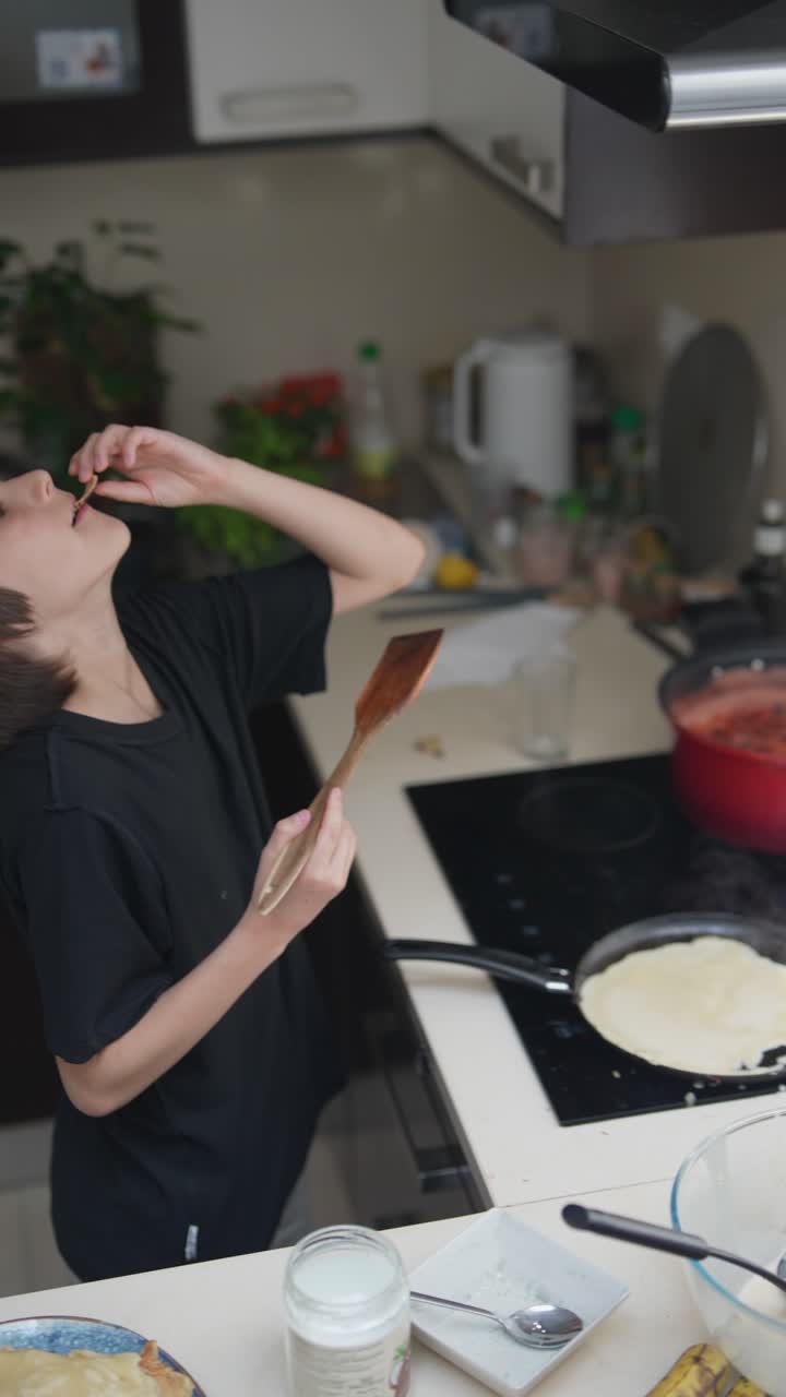 Child cooking pancakes in the kitchen