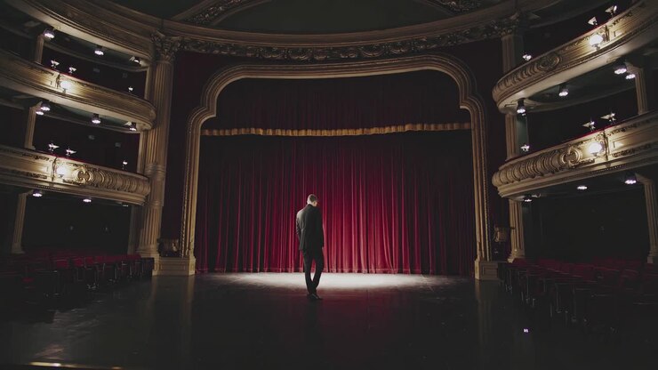 Man Standing on Stage of Old Theatre