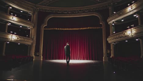 man standing on stage of old theatre